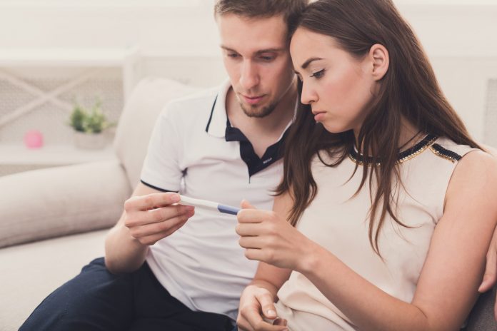Sad couple after pregnancy test result copy space