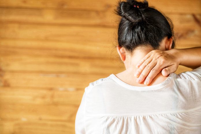 Woman feeling exhausted and suffering from neck pain.