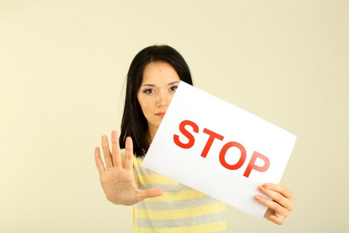 21203840 - girl showing stop sign on grey background