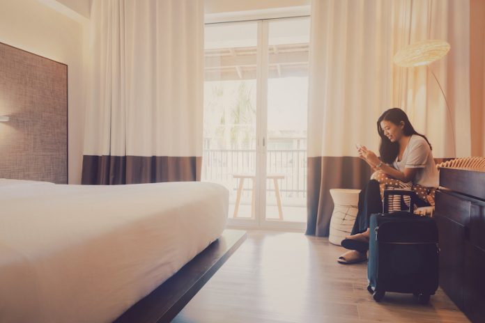 Asian,Women,Are,Staying,In,A,Hotel,Room.sitting,And,Using